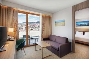 une chambre d'hôtel avec un canapé et un lit dans l'établissement Hilton Garden Inn Tirana, à Tirana