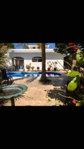 een gebouw met een boom en een zwembad bij Villa Ruiz @ the 7th hole in Manzanillo