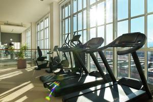 a gym with several tread machines in a room with windows at DoubleTree by Hilton Turin Lingotto in Turin