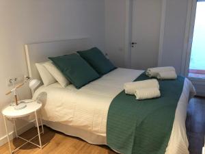 a bedroom with a large bed with green pillows at Gaudi Street Apartments in Sitges