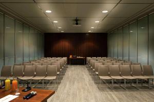 an empty conference room with chairs and a podium at DoubleTree by Hilton Turin Lingotto in Turin