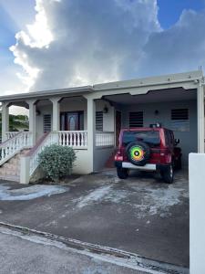 un jeep rojo estacionado frente a una casa en Mountain view Apartment, en Basseterre