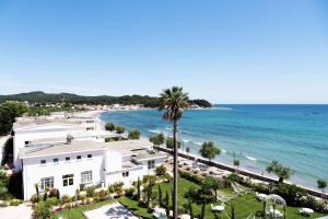 a view of a beach with a white building and the ocean at Grand Hotel Des Sablettes Plage, Curio Collection By Hilton in La Seyne-sur-Mer