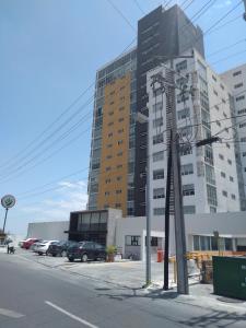 een hoog gebouw met auto's geparkeerd op een parkeerplaats bij Suite Lof 206 in Monterrey