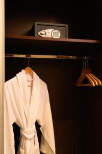 a robe hanging on a shelf with a clock at PLAYA DEL PACHA Suites Hotel in Marina Smir