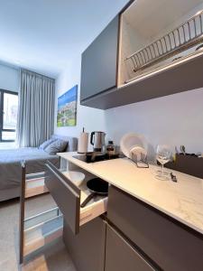 Habitación con cama y cocina con encimera. en White Door Apartments en Haifa