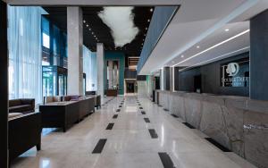 a lobby of a building with couches and windows at DoubleTree by Hilton Novosibirsk in Novosibirsk