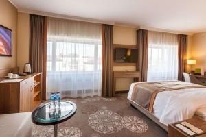 una habitación de hotel con una cama grande y una mesa en DoubleTree by Hilton Hotel Tyumen, en Tyumen