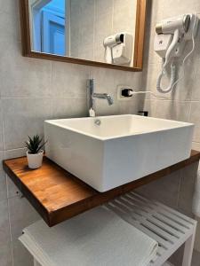 W łazience znajduje się biała umywalka i lustro. w obiekcie Mediterraneo Apartment w mieście Ercolano