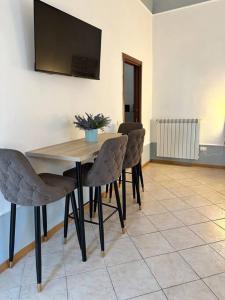 a dining room table with chairs and a television on the wall at Mediterraneo Apartment in Ercolano