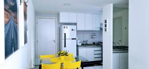 uma cozinha com uma mesa amarela e cadeiras amarelas em Melhor localização em Boa Viagem! em Recife