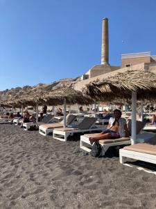 un groupe de personnes assises sur une plage avec des parasols dans l'établissement Studio - Garden in the city, à Vintimille