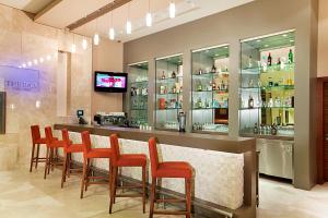 a bar with a row of orange chairs in a restaurant at Hilton Garden Inn Sanliurfa in Urfa