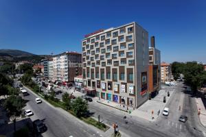 ein hohes Gebäude in einer Stadtstraße mit Autos in der Unterkunft Hilton Garden Inn Kutahya in Kütahya