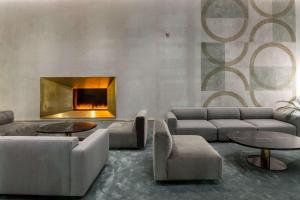 a living room with couches and tables and a fireplace at Hilton Garden Inn Tbilisi Chavchavadze in Tbilisi City