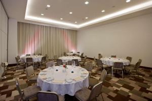 una habitación llena de mesas y sillas con manteles blancos en Hilton Garden Inn Kutahya, en Kütahya