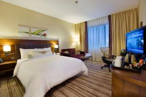 a hotel room with a bed and a flat screen tv at Hilton Garden Inn Kutahya in Kütahya