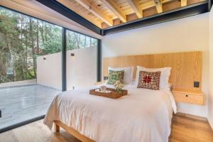 1 dormitorio con cama grande y ventana grande en CASA NUEVA en Avandaro rodeada de Naturaleza, en Valle de Bravo