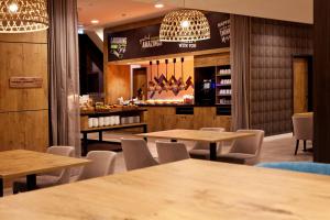 a restaurant with tables and chairs and a bar at Hampton By Hilton Aachen Tivoli in Aachen