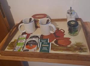 a wooden table with two cups on top of it at Ventanas al cerro recargado! in La Rioja