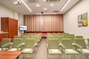 una sala de conferencias vacía con sillas y una pantalla en Hilton Garden Inn Krasnodar, en Krasnodar