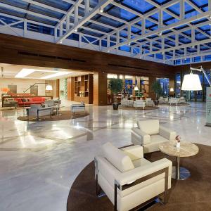 a lobby with white chairs and tables in a building at Hilton Garden Inn Konya in Konya