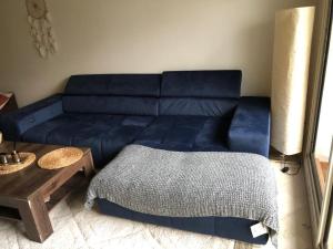 ein blaues Sofa im Wohnzimmer mit einem Tisch in der Unterkunft Appartement meublé à louer in Settat