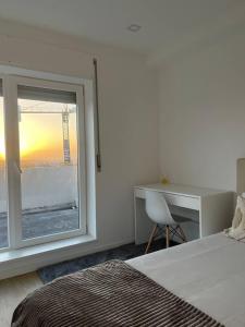 a bedroom with a bed and a desk and a window at Quarto duplo com casa de banho exclusiva no Porto in Porto