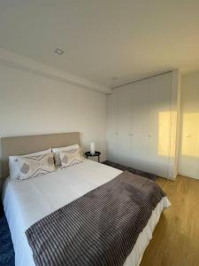 a bedroom with a large bed and a white wall at Quarto duplo com casa de banho exclusiva no Porto in Porto