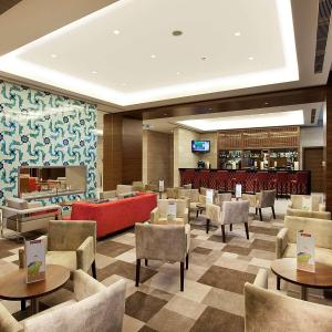 a hotel lobby with tables and chairs and a bar at Hilton Garden Inn Konya in Konya