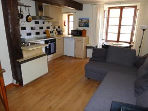 1 Bedroom Flat in Historic Cooperage Apartments Leith في إدنبرة: غرفة معيشة مع أريكة ومطبخ