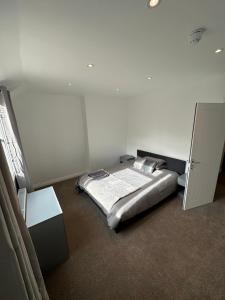 a bedroom with a bed and a white wall at 3 bedroom house Maidstone in Maidstone