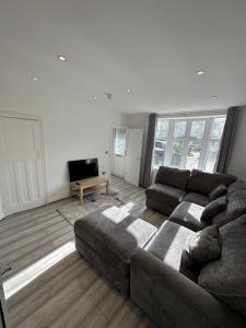 a living room with a couch and a television at 3 bedroom house Maidstone in Maidstone