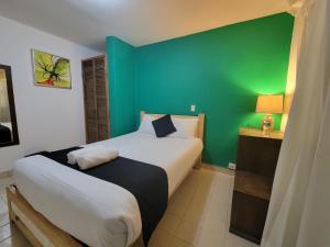 a bedroom with a green wall and a bed at Jardines de Luz in San Cristóbal de Las Casas +36 photos