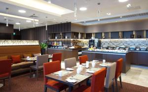 a restaurant with tables and chairs and a bar at Hilton Garden Inn Volgograd in Volgograd