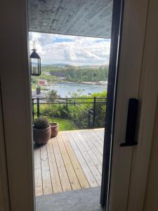 una puerta abierta a una terraza con vistas al río en Apartments Bergen with sea view!, en Bergen