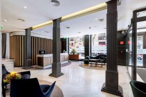 een lobby met zuilen en stoelen in een gebouw bij DoubleTree by Hilton Madrid-Prado in Madrid
