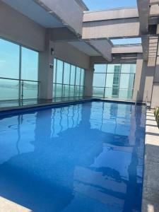 - une grande piscine dans un bâtiment doté de fenêtres dans l'établissement Hermosa suite vista al rio 306, à Guayaquil