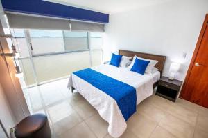 - une chambre avec un lit doté d'oreillers bleus et d'une fenêtre dans l'établissement Hermosa suite vista al rio 306, à Guayaquil