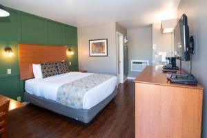 Habitación de hotel con cama y escritorio en Nordic Inn and Suites en Portland