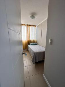 a small room with a bed and a door at DEPARTAMENTO ARRIENDO DIARIO in La Serena