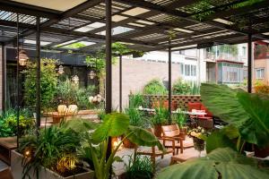 un patio con mesas, sillas y plantas en Alexandra Barcelona Hotel, Curio Collection by Hilton, en Barcelona