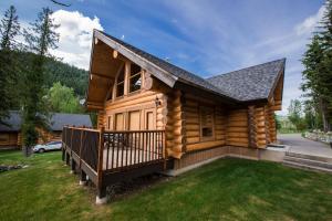 a log cabin with a porch and a yard at Alpine Meadows Resort in Clearwater