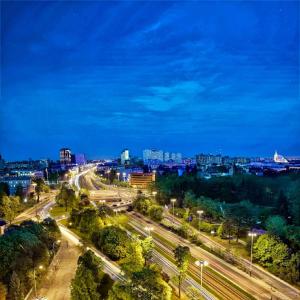 um horizonte da cidade à noite com estradas e luzes de rua em DoubleTree by Hilton Łódź em Lódź