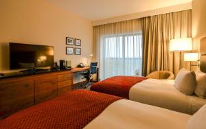 a hotel room with two beds and a flat screen tv at DoubleTree by Hilton Łódź in Łódź