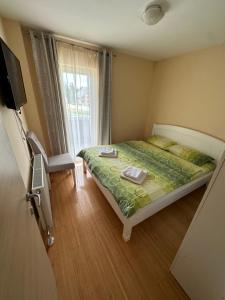 a small bedroom with a bed and a window at Apartments Popović in Žabljak