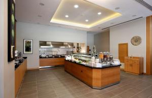 a restaurant with a counter in the middle of a kitchen at Hilton Garden Inn Erzincan in Erzincan