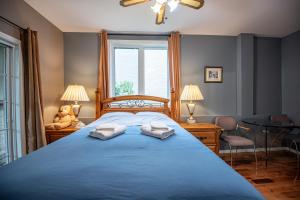 ガティノーにあるGoodview Le Mont-Lucのベッドルーム1室(ブルーベッド1台、タオル2枚付)