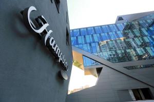 a building with a sign on the side of it at Hampton By Hilton Olsztyn in Olsztyn