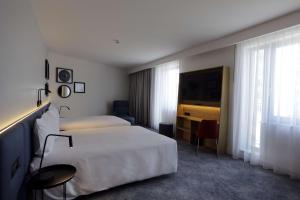 a hotel room with two beds and a television at Hampton By Hilton Olsztyn in Olsztyn